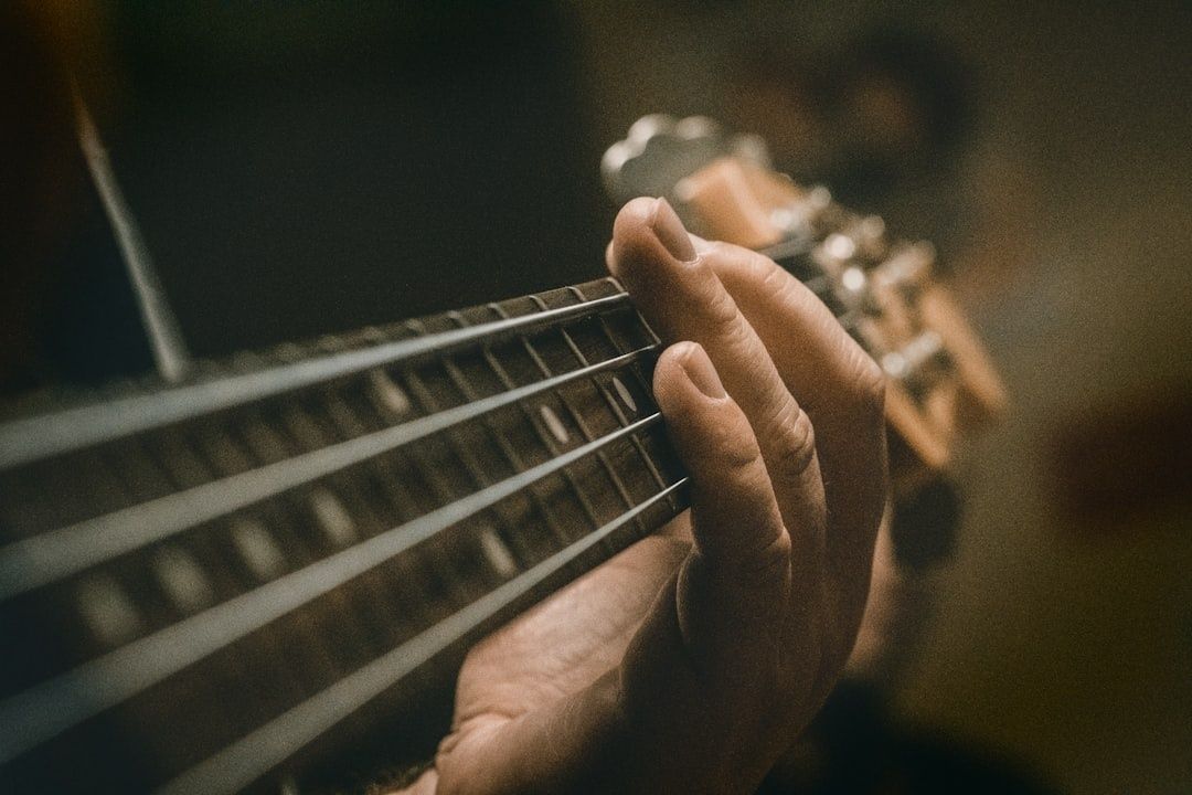 Nahaufnahme einer Hand am Hals eines elektrischen Basses
